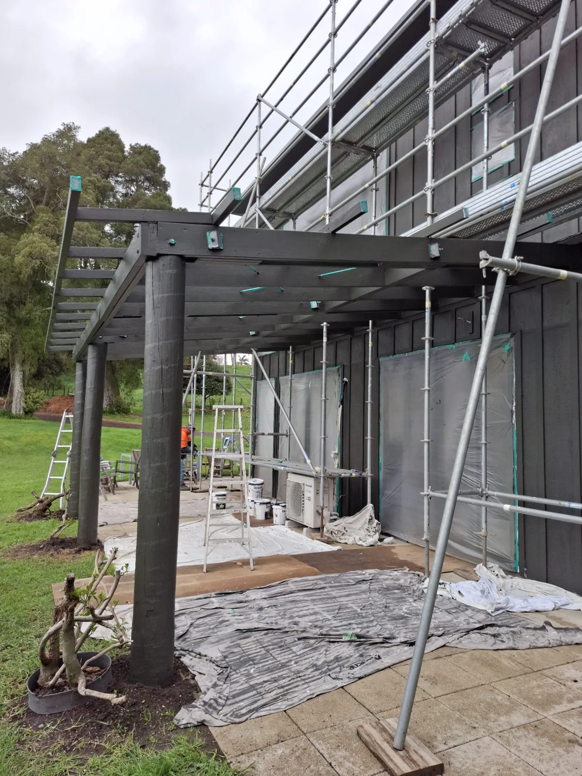 Exterior timber structure being painted with scaffolding in place